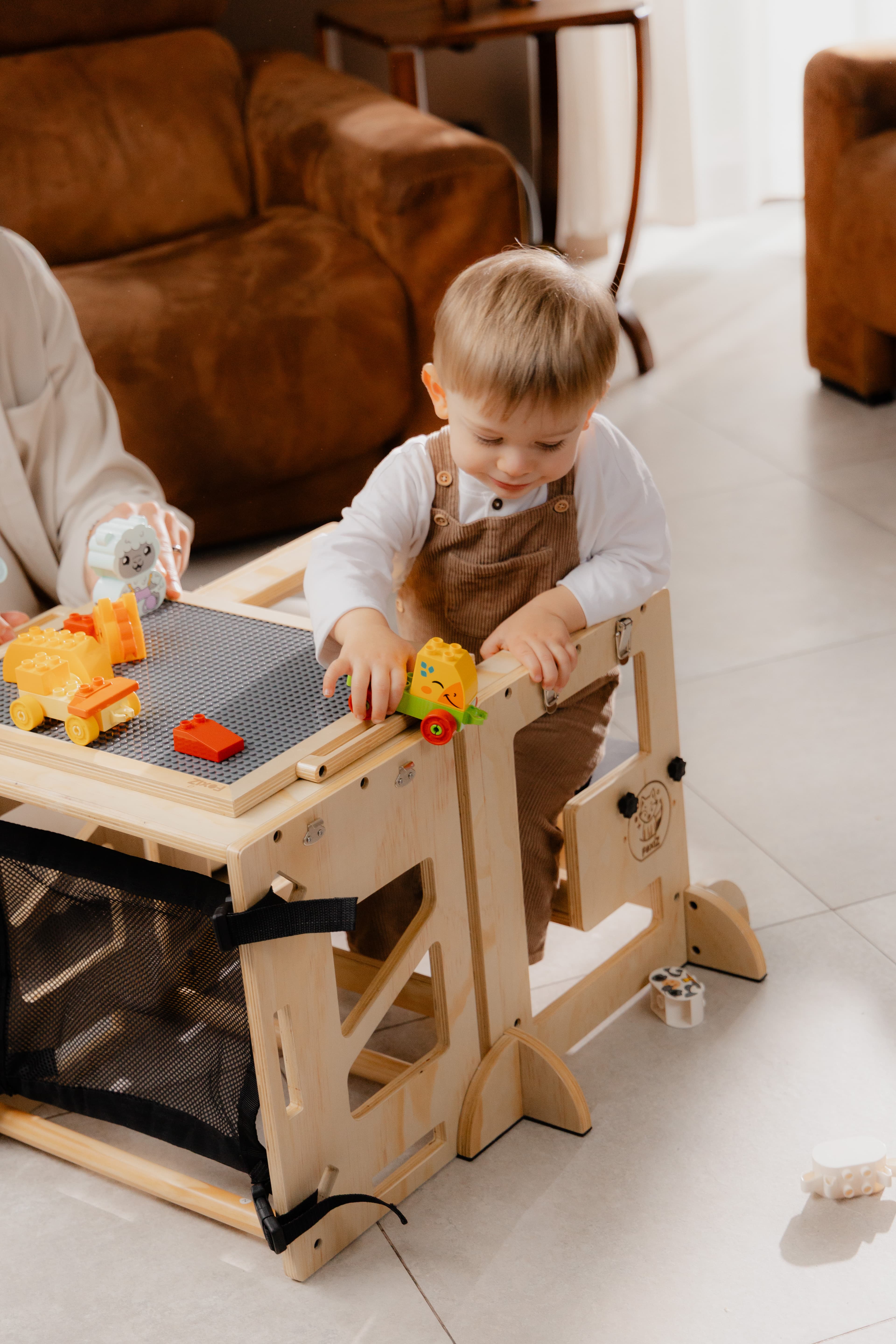 Enfant jouant sur le plateau de la VersaTower, tour d'apprentissage Montessori